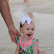Berkleigh Grace is registered to the contest to win money with this photo: child, toddler, water, splashing, hand, adult, bow, dress, colorful_clothing, smiling, happy, outdoor, beach, sand, play, person, summer, cute, fun, family