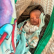 Leo is registered to the contest to win money with this photo: baby, blanket, bedding, child, cozy, comfort, cushion, face, furniture, handwear, infant, inside, pattern, person, resting, sleepy, soft, toddler, wrapped, warm