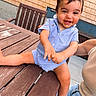baby, child, smiling, blue_clothing, striped_clothing, wooden_table, outdoor, table, chair, person, face, happy, infant, casual, summer, candid, cute, playful, skin, sitting