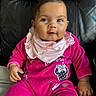 baby, child, infant, pink_clothing, bib, minnie_mouse, sitting, leather_chair, cute, portrait, smiling, face, hand, indoors, young_child, happy, casual, cozy, comfortable, bright_colors