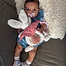 Aaliyah is registered to the contest to win money with this photo: adorable, baby, blue_dress, bunny, child, comfort, couch, cozy, cute, indoor, infant, lying_down, pacifier, person, pillow, plush_toy, sneakers, sock, soft_texture, toy