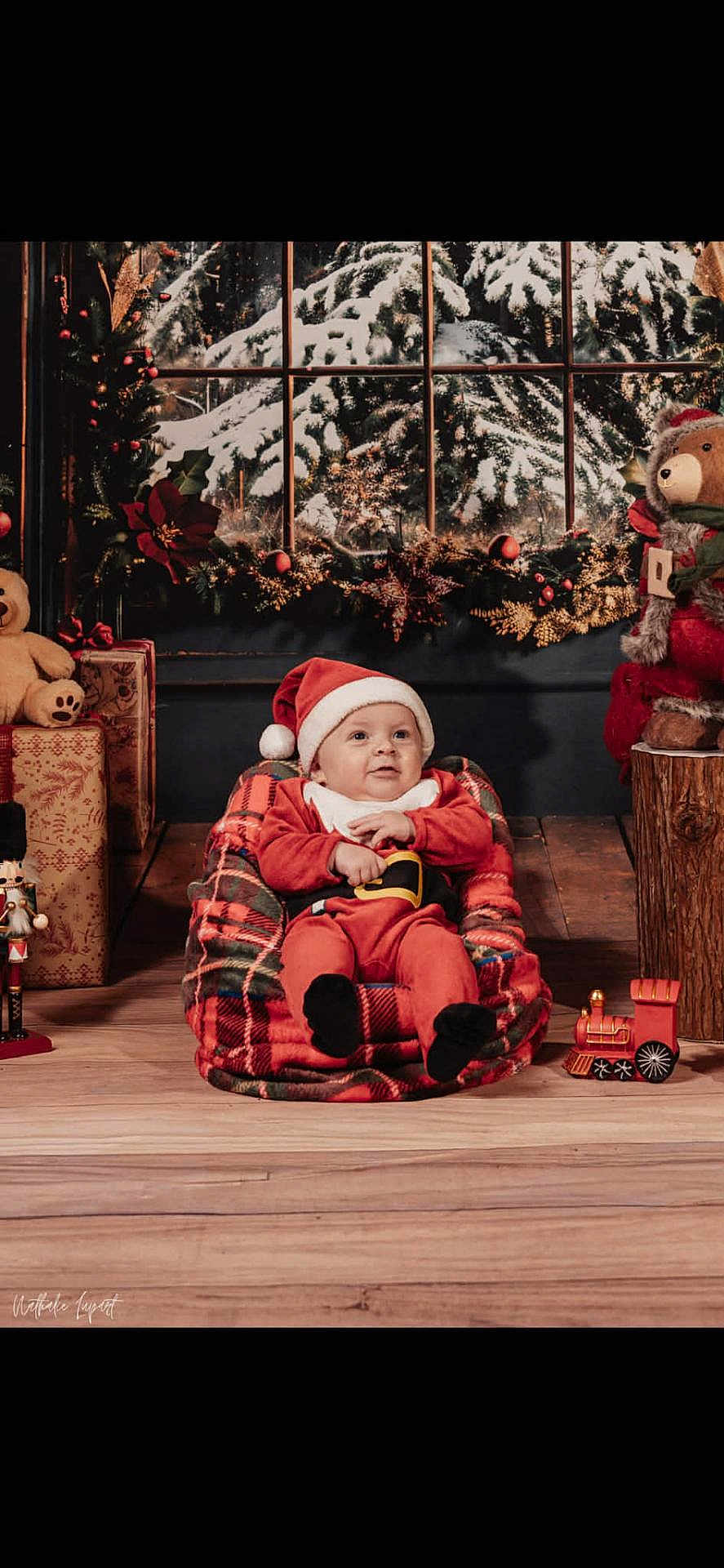 Isaac participe au concours pour gagner de l'argent avec cette photo : baby, santa_hat, plaid, christmas, holiday, teddy_bear, gift, toy_train, nutcracker, window, snow, festive, decorations, wood_floor, red_clothing, child, smiling, indoor, cozy, holiday_season