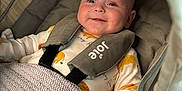 Archie joined the competition — help win amazing prizes! baby, smile, stroller, blanket, infant, clothing, cute, child, happy, face, seatbelt, fabric, knitted, indoors, person, newborn, soft, cozy, resting, small_hand