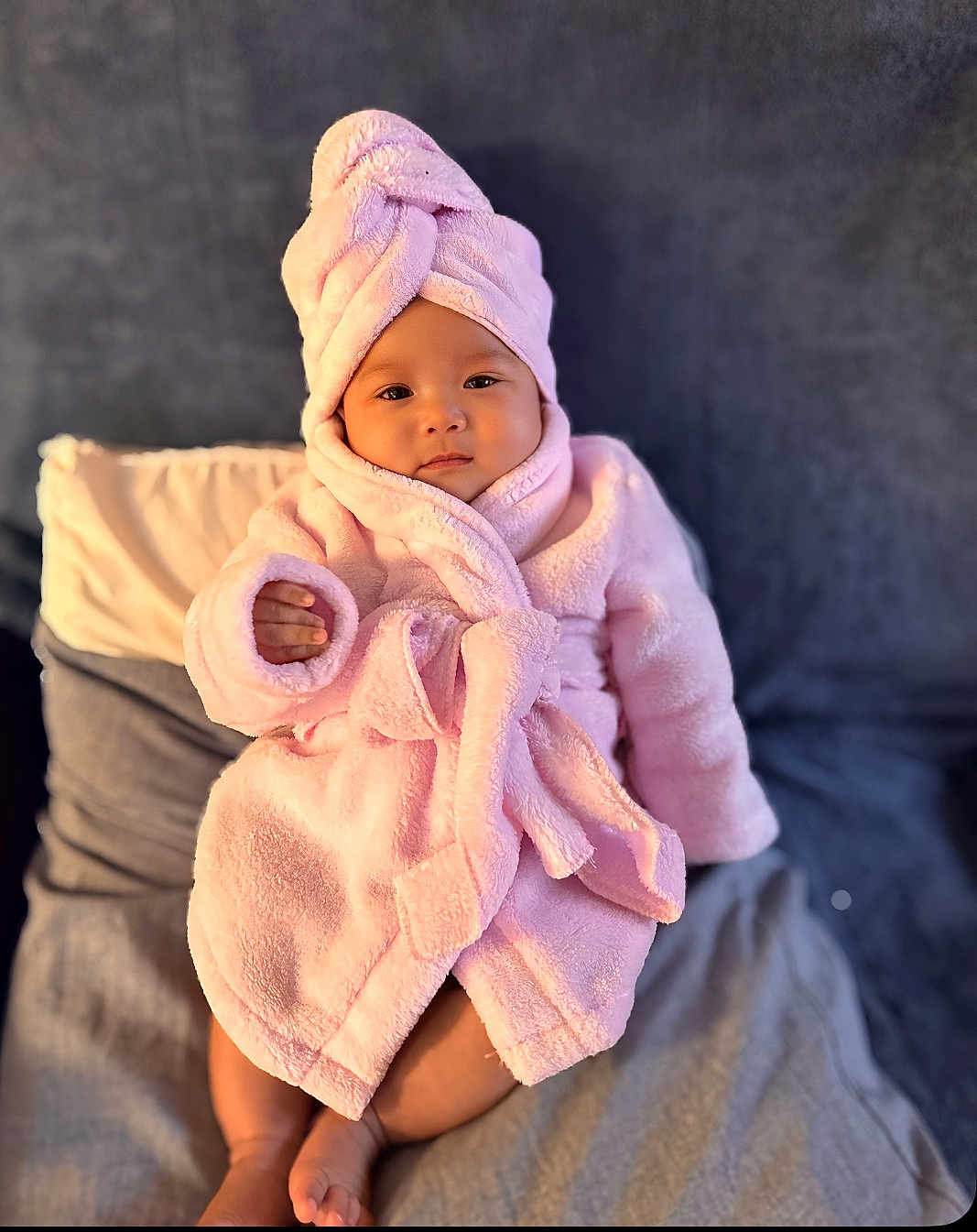 Isabelle joined the competition — help win amazing prizes! baby, child, pink_robe, towel_turban, bed, pillow, blanket, soft_fabric, infant, portrait, indoors, cute, cozy, relaxed, person, smiling, face, skin, fingers, feet