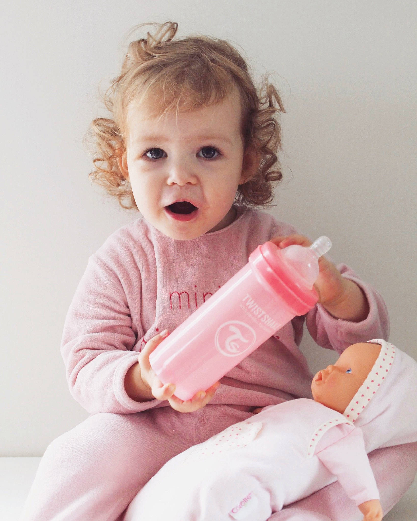 éléanore participe au concours pour gagner de l'argent avec cette photo : baby, baby_bottle, baby_grabbing_for_something, baby_products, baby_toddler_clothing, blond, bottle, child, eyelash, hand, peach, person, pink, plastic_bottle, skin, surprise, toddler