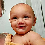 Grayson is registered to the contest to win money with this photo: baby, child, towel, smile, face, indoor, person, skin, expression, holding, adult, curly_hair, cute, portrait, human, happy, newborn, infant, close_up, warm