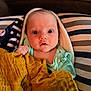Delilah joined the competition — help win amazing prizes! baby, blanket, blue_clothing, couch, face, head, infant, indoors, person, portrait, striped_pillow, toddler, warm_light, wide_eyes, wrapped, cozy, soft_texture, young_child, cute, resting