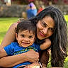 adult, blue_shirt, child, family, family_photo, flowers, garden, grass, happy, hugging, long_hair, mother, outdoor, portrait, ring, sitting, smiling, sunlight, toddler, watch