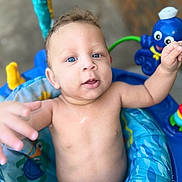 Kobe is registered to the contest to win money with this photo: baby, infant, child, blue_eyes, bare_chest, baby_seat, toy, octopus_toy, colorful, playful, indoor, portrait, curious, cute, young_child, smiling, close_up, skin, expression, person