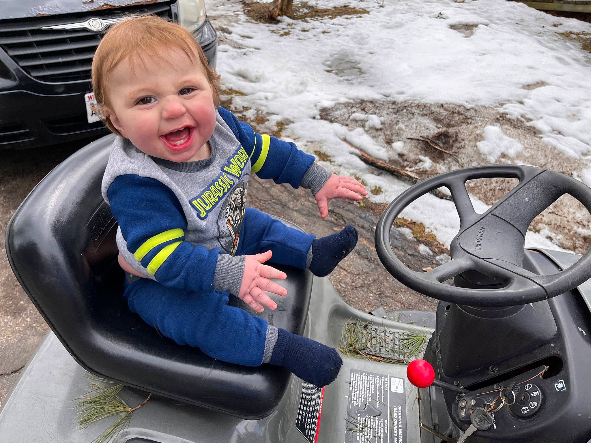 Carter is registered to the contest to win money with this photo: auto_part, automotive_design, automotive_exterior, automotive_mirror, automotive_tire, automotive_wheel_system, car, grille, mode_of_transport, motor_vehicle, person, plant, smile, steering_part, steering_wheel, toddler, tree, vehicle, vehicle_door, white