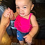 toddler, child, smiling, holding_hand, pink_top, blue_shorts, indoor, carpet, footwear, white_sandals, black_sofa, happy, cute, person, skin, hand, face, standing, home, young_child