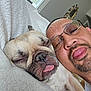 dog, man, face, tongue, sleepy, blanket, glasses, indoor, window, mirror, facial_hair, closeup, pet, resting, cozy, cute, relaxed, home, portrait, light