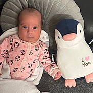 Mané participe au concours pour gagner de l'argent avec cette photo : baby, blanket, child, comfort, cozy, cushion, cute, fabric, gray_cushion, indoor, infant, lying_down, newborn, penguin_pattern, penguin_plush, person, pink_onesie, plush_toy, soft_toy, warm