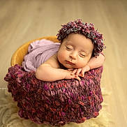 Mané a rejoint le concours — aidez-le/la à gagner de superbes lots ! baby, sleeping, flower_crown, basket, blanket, knit, infant, cute, peaceful, soft_lighting, portrait, newborn, wooden_floor, cozy, resting, wrapped, hands, face, headwear, indoor