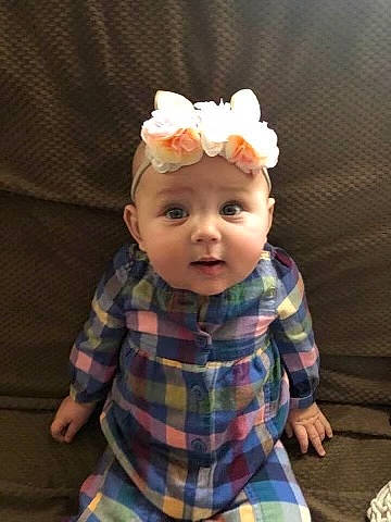 Kensley is registered to the contest to win money with this photo: baby, baby_toddler_clothing, child, chin, embellishment, fashion_accessory, flower, hair_accessory, hat, headband, headgear, headwear, iris, pattern, person, plaid, sitting, sleeve, t_shirt, tartan