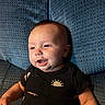 Atlas joined the competition — help win amazing prizes! baby, child, infant, smiling, happy, portrait, close_up, sitting, cushion, blue, black_clothing, gold_pattern, sun_design, indoors, face, eyes, mouth, arms, textured_fabric, photography