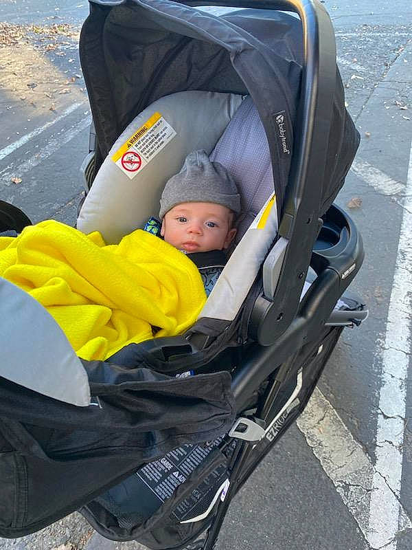 Keaton is registered to the contest to win money with this photo: auto_part, baby, baby_carriage, baby_products, baby_toddler_clothing, child, comfort, headwear, person, personal_protective_equipment, product, recreation, sitting, toddler