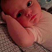 Athena is registered to the contest to win money with this photo: baby, infant, face, arm, bedding, pattern, sleepwear, resting, lying_down, portrait, closeup, soft_lighting, cute, child, young, indoors, comfort, peaceful, skin, expression