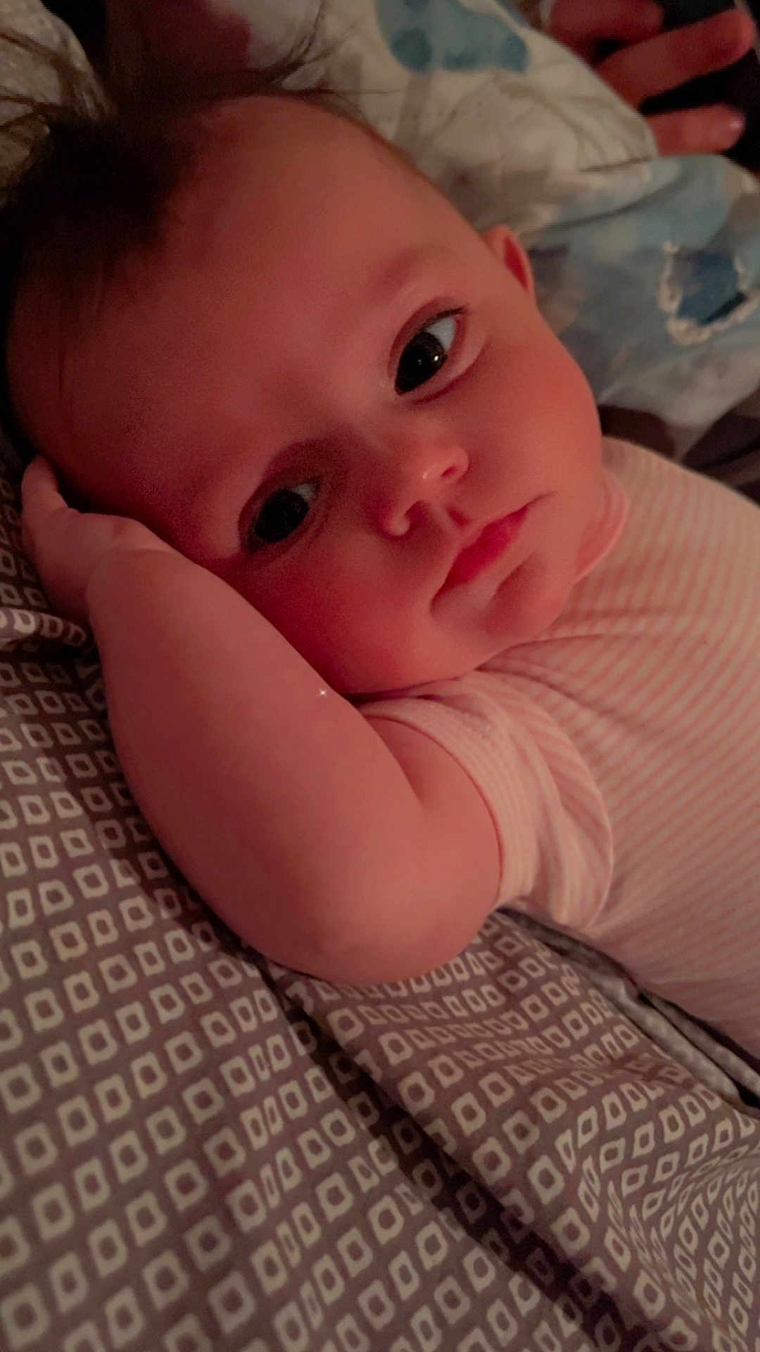 Athena is registered to the contest to win money with this photo: baby, infant, face, arm, bedding, pattern, sleepwear, resting, lying_down, portrait, closeup, soft_lighting, cute, child, young, indoors, comfort, peaceful, skin, expression