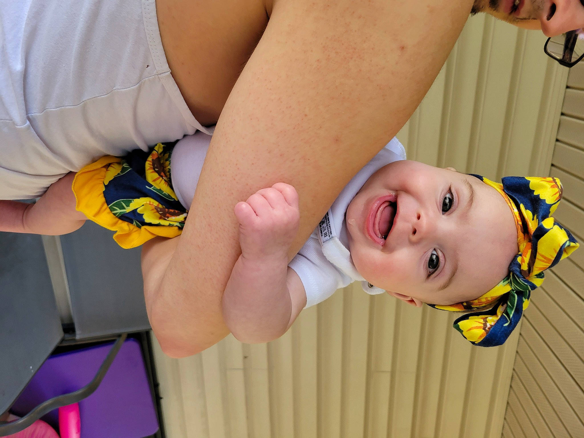 Maci is registered to the contest to win money with this photo: arm, baby_toddler_clothing, dress, elbow, finger, gesture, glasses, hand, happy, headwear, human_body, joint, knee, mouth, orange, person, skin, smile, thigh, thumb