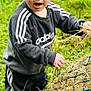 adidas, child, clothing, curious, exploration, expression, grass, green_boots, hay, nature, netting, outdoor, pants, person, polka_dot, portrait, red_hair, standing, sweatshirt, toddler