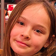 Leana a rejoint le concours — aidez-le/la à gagner de superbes lots ! child, girl, face, portrait, smile, long_hair, earring, indoor, person, young, closeup, natural_light, human, expression, casual, warm, background_blur, head, skin, eyebrows