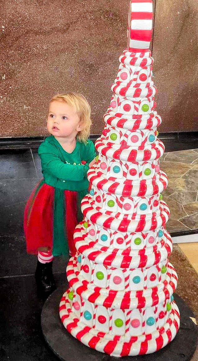 Presleigh is registered to the contest to win money with this photo: christmas_decoration, christmas_ornament, christmas_tree, dress, event, formal_wear, green, happy, holiday, holiday_ornament, magenta, ornament, pattern, person, pink, red, sleeve, textile, toddler, tree