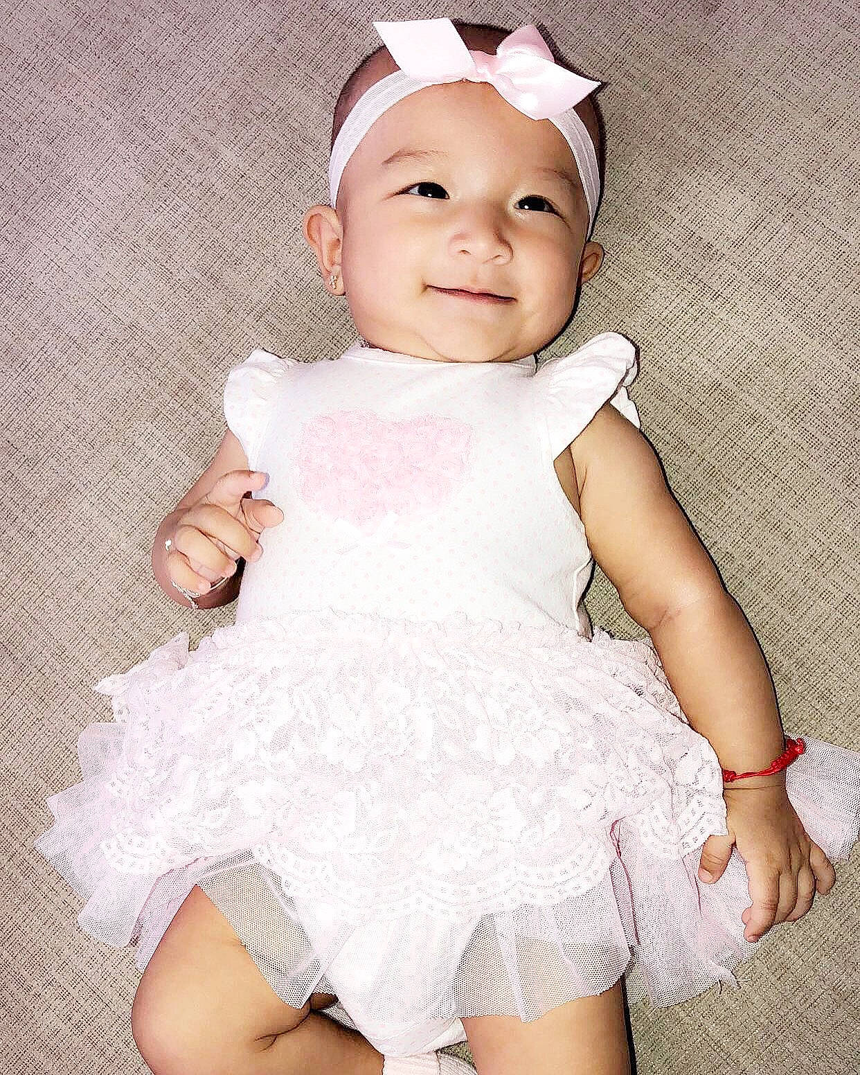 Delilah is registered to the contest to win money with this photo: baby, baby_products, baby_toddler_clothing, beauty, child, child_model, clothing, design, dress, ear, fashion_accessory, hair_accessory, person, pink, product, ruffle, skin, sleeve, smile, toddler