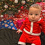 Benjamin participe au concours pour gagner de l'argent avec cette photo : baby, black_blanket, celebration, child, christmas_ornaments, christmas_tree, cute, decorations, face, festive_clothing, holiday, holiday_lights, home, indoors, presents, red_clothing, santa_outfit, sitting, smiling, wrapped_gifts
