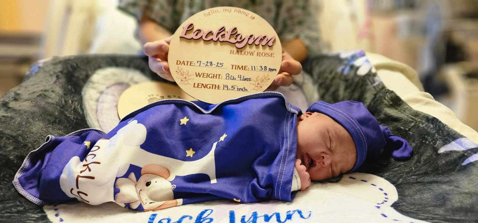 Locklynn is registered to the contest to win money with this photo: newborn, baby, sleeping, blanket, hat, person, sign, wooden_sign, birth_details, indoor, soft_toys, plush_surface, blue, stars, cute, peaceful, wrapped, infant, portrait, resting
