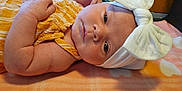 Locklynn joined the competition — help win amazing prizes! baby, infant, face, headband, bow, yellow_clothing, blanket, orange, heart_pattern, hand, skin, closeup, lying_down, indoors, cute, newborn, soft_texture, portrait, child, peaceful