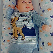Maël a rejoint le concours — aidez-le/la à gagner de superbes lots ! baby, infant, child, lion_king, clothing, onesie, cushion, stars, mickey_mouse, pattern, soft, comfortable, lying_down, cute, portrait, indoors, sleeping_area, colorful, young_child, casual