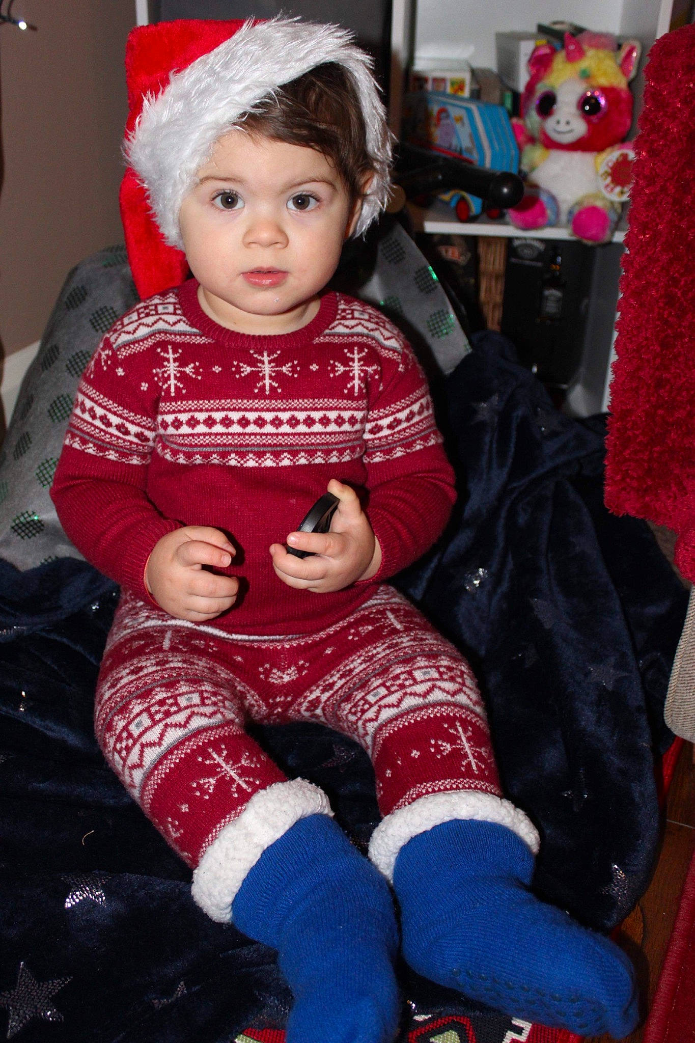 Matei is registered to the contest to win money with this photo: baby, baby_toddler_clothing, child, christmas, christmas_eve, event, eye, happy, headwear, holiday, human_body, lap, person, pink, red, sitting, sleeve, sock, textile, thigh