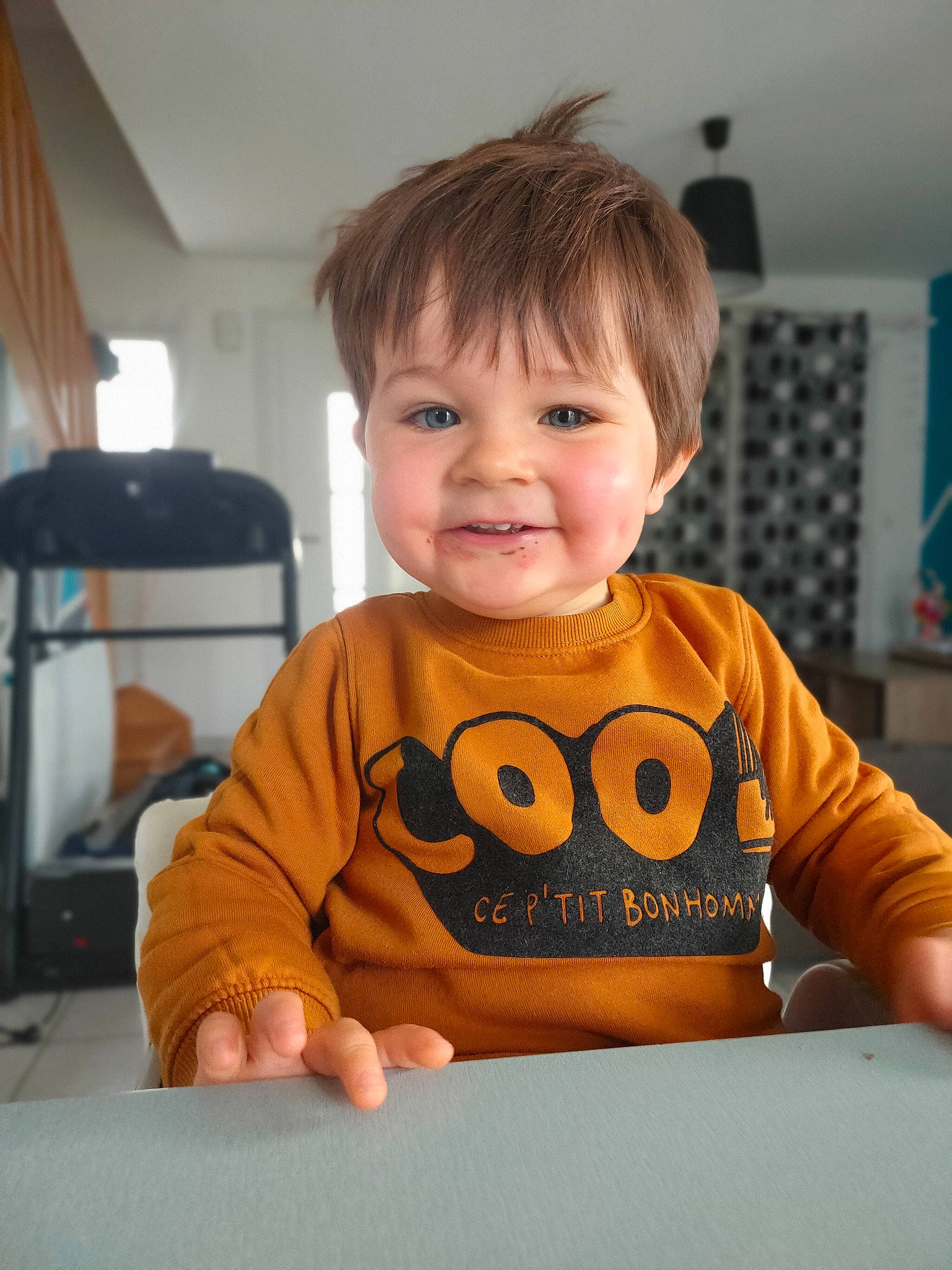 Daryl a rejoint le concours — aidez-le/la à gagner de superbes lots ! baby, baby_toddler_clothing, cheek, child, curtain, finger, flooring, fun, happy, joy, lamp, person, room, sitting, skin, sleeve, smile, standing, t_shirt, table
