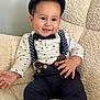 baby, child, smiling, hat, bow_tie, suspenders, shirt, pants, sitting, indoor, cozy, chair, cute, portrait, happy, young, fashion, clothing, face, person