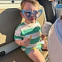 adult_hand, boat, casual_clothing, child, cup, funny, happy, heart_shaped, leisure, outdoor, portrait, relaxation, seat, shorts, snack, striped_shirt, summer, sunglasses, sunlight, toddler