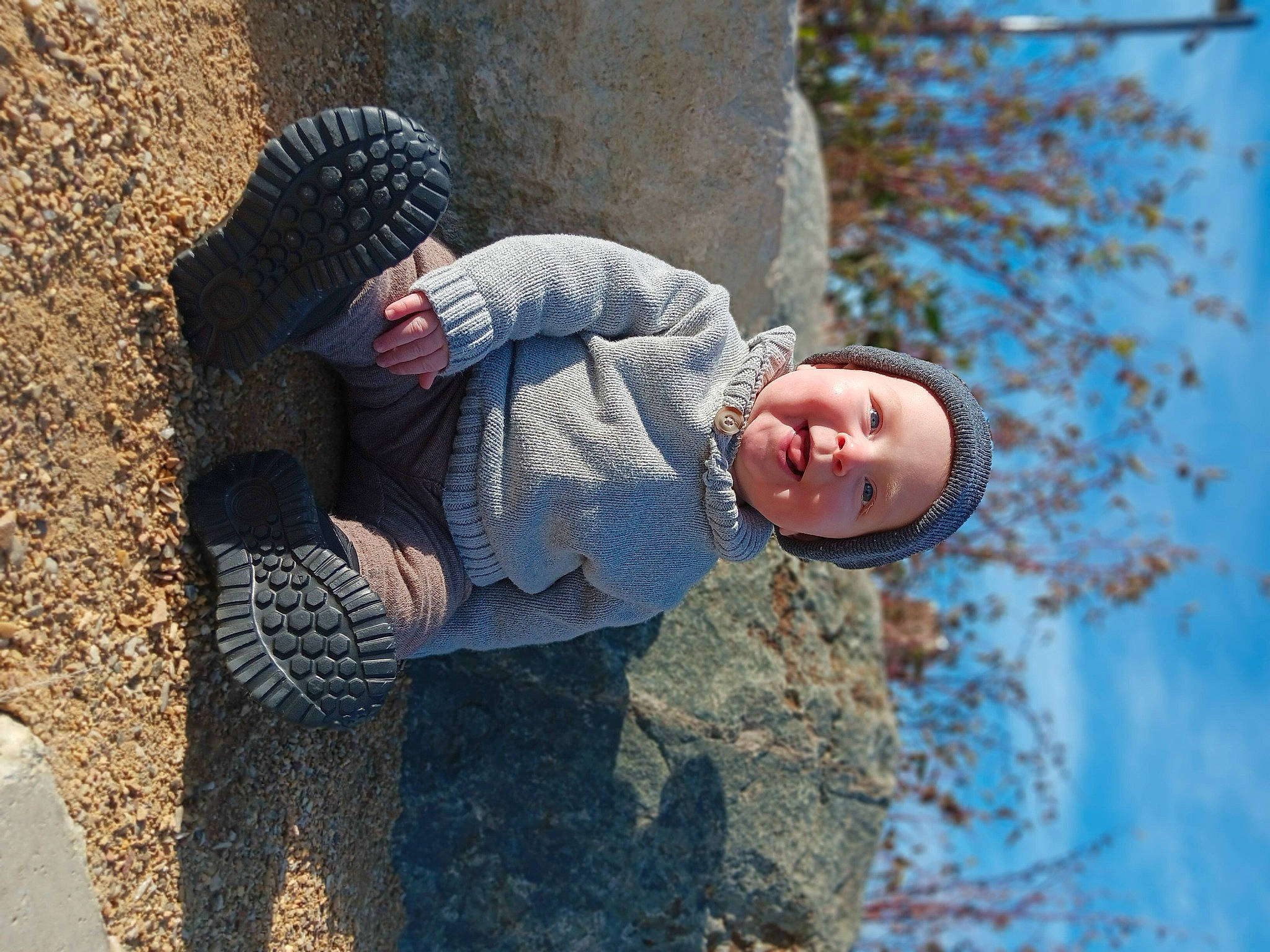 Lucas joined the competition — help win amazing prizes! cap, child, facial_expression, freezing, fun, grass, happy, hat, headwear, leisure, people_in_nature, person, plant, rock, sitting, sky, soil, toddler, tree, twig