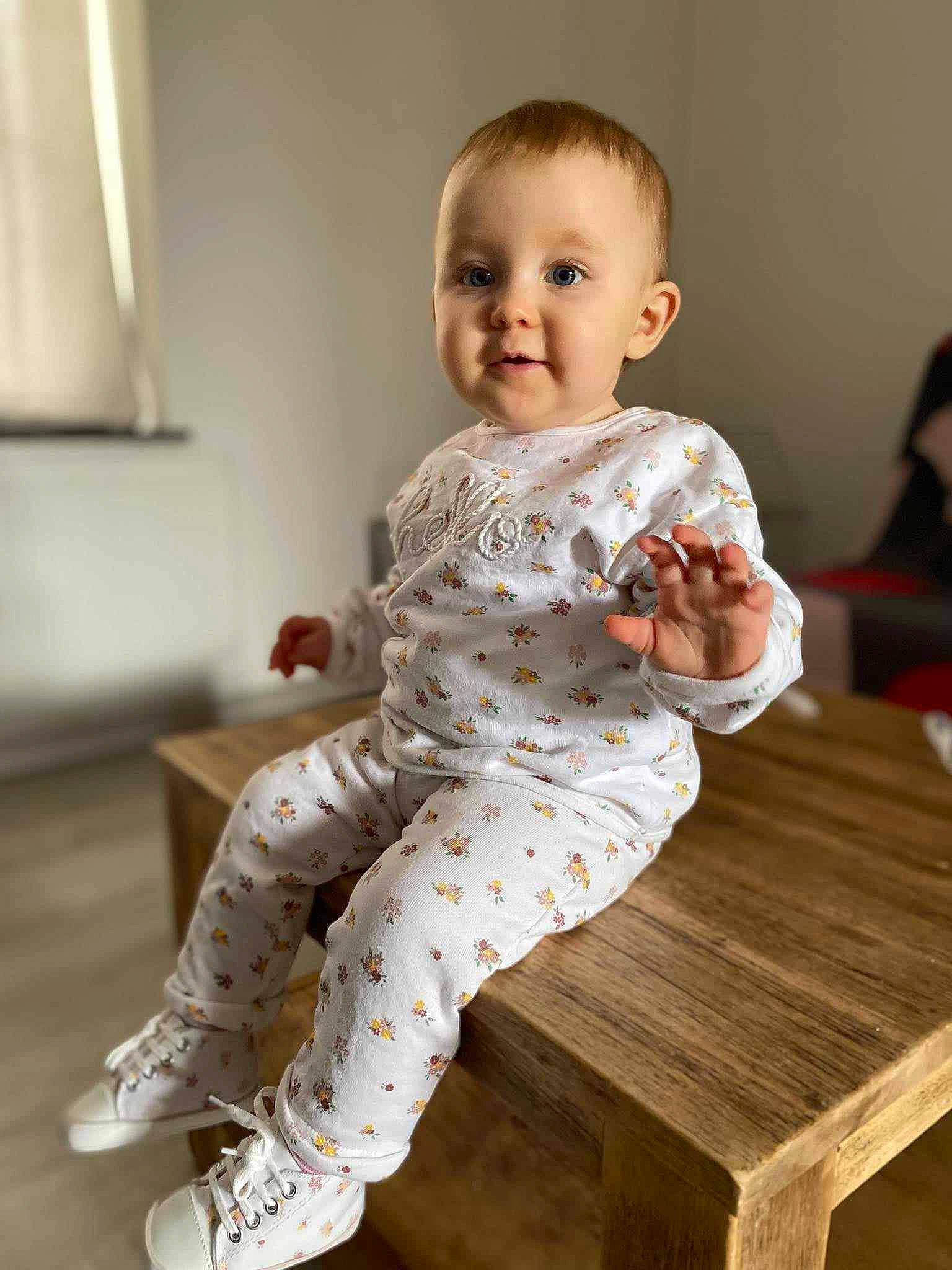 Lyana participe au concours pour gagner de l'argent avec cette photo : active_pants, baby, baby_toddler_clothing, barefoot, child, comfort, facial_expression, flooring, foot, human_leg, knee, pattern, person, sitting, sleeve, smile, table, thigh, thumb, toddler