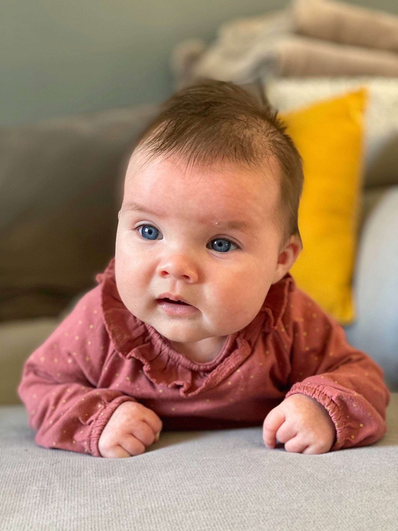 Judith participe au concours pour gagner de l'argent avec cette photo : baby, baby_toddler_clothing, cheek, chin, close_up, comfort, eye, face, floor, flooring, happy, head, iris, lip, nose, person, skin, sleeve, smile, toddler