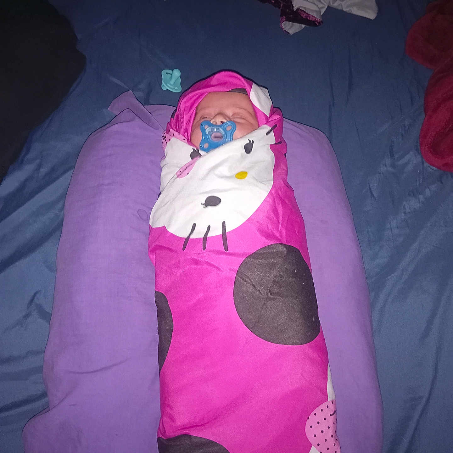 Loraly is registered to the contest to win money with this photo: baby, newborn, sleeping, infant, pacifier, pink, swaddle, blanket, pillow, bed, indoors, portrait, face, clothing, textile, purple, magenta, cozy, resting, cute
