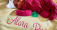 Alora is registered to the contest to win money with this photo: newborn, baby, sleeping, blanket, knit, headband, bow, pacifier, clothing, infant, pink, magenta, cozy, cute, resting, portrait, babywear, soft, peaceful, child