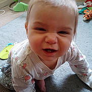 Sofia is registered to the contest to win money with this photo: baby, crawling, face, funny_expression, indoors, carpet, toy, child, clothing, cute, person, expression, floor, home, infant, casual, playtime, smiling, young_child, closeup