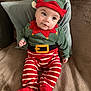Mylan participe au concours pour gagner de l'argent avec cette photo : baby, child, elf_costume, holiday, red_and_white_stripes, green_hat, belt, couch, pillow, indoor, portrait, smiling, cute, festive, costume, soft_texture, seated, holiday_outfit, infant, happy