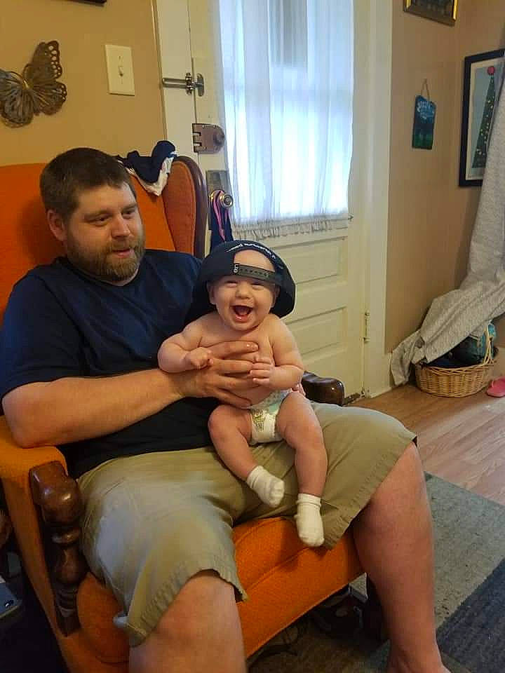 Atticus is registered to the contest to win money with this photo: arthropod, butterfly, comfort, curtain, event, hat, headwear, human_leg, insect, joint, knee, lap, leg, moths_and_butterflies, person, picture_frame, pollinator, shorts, shoulder, smile