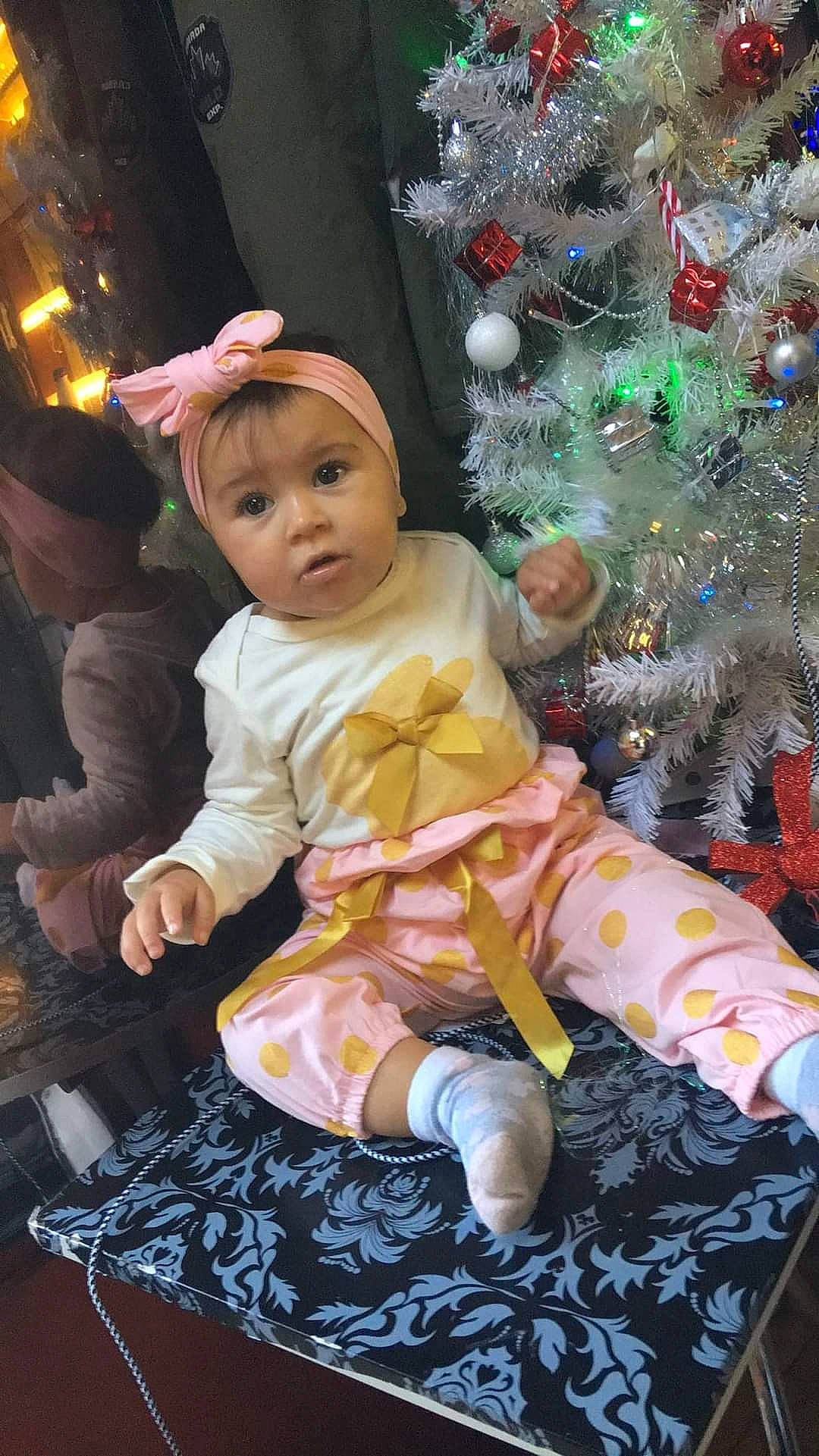 Azalya participe au concours pour gagner de l'argent avec cette photo : baby, baby_toddler_clothing, child, christmas, christmas_decoration, christmas_eve, christmas_ornament, christmas_tree, event, fun, happy, holiday, holiday_ornament, lap, ornament, person, sitting, skin, surprise, toddler