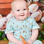 Garrett joined the competition — help win amazing prizes! baby, child, blue_eyes, carrot_pattern, toy, sitting, smiling, cute, infant, outfit, wooden_background, flowers, decor, portrait, happy, indoor, plush, small_hands, feet, bright