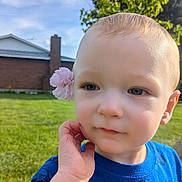 Finn is registered to the contest to win money with this photo: toddler, child, flower, pink_flower, blue_shirt, outdoor, grass, sky, greenery, portrait, face, hand, cute, daylight, nature, expression, young_child, head, person, casual