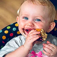 Oakland joined the competition — help win amazing prizes! baby, child, infant, smiling, happy, blue_eyes, blond_hair, portrait, close_up, eating, food, messy_face, hands, sitting, high_chair, polka_dots, indoor, colorful, bow, shirt