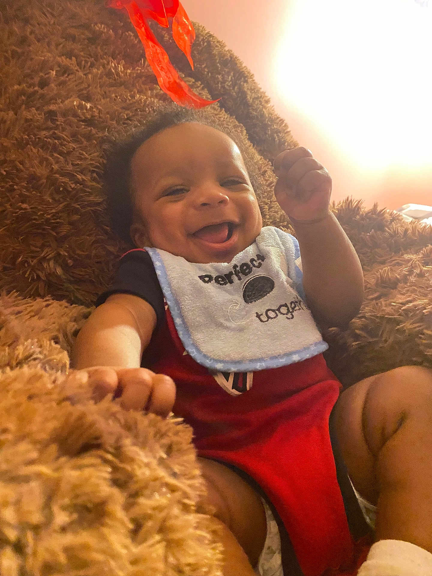 Cameron is registered to the contest to win money with this photo: baby, smiling, bib, blanket, cozy, happy, infant, child, face, portrait, cute, clothing, lying_down, indoor, warm_light, fuzzy, human, newborn, expression, soft