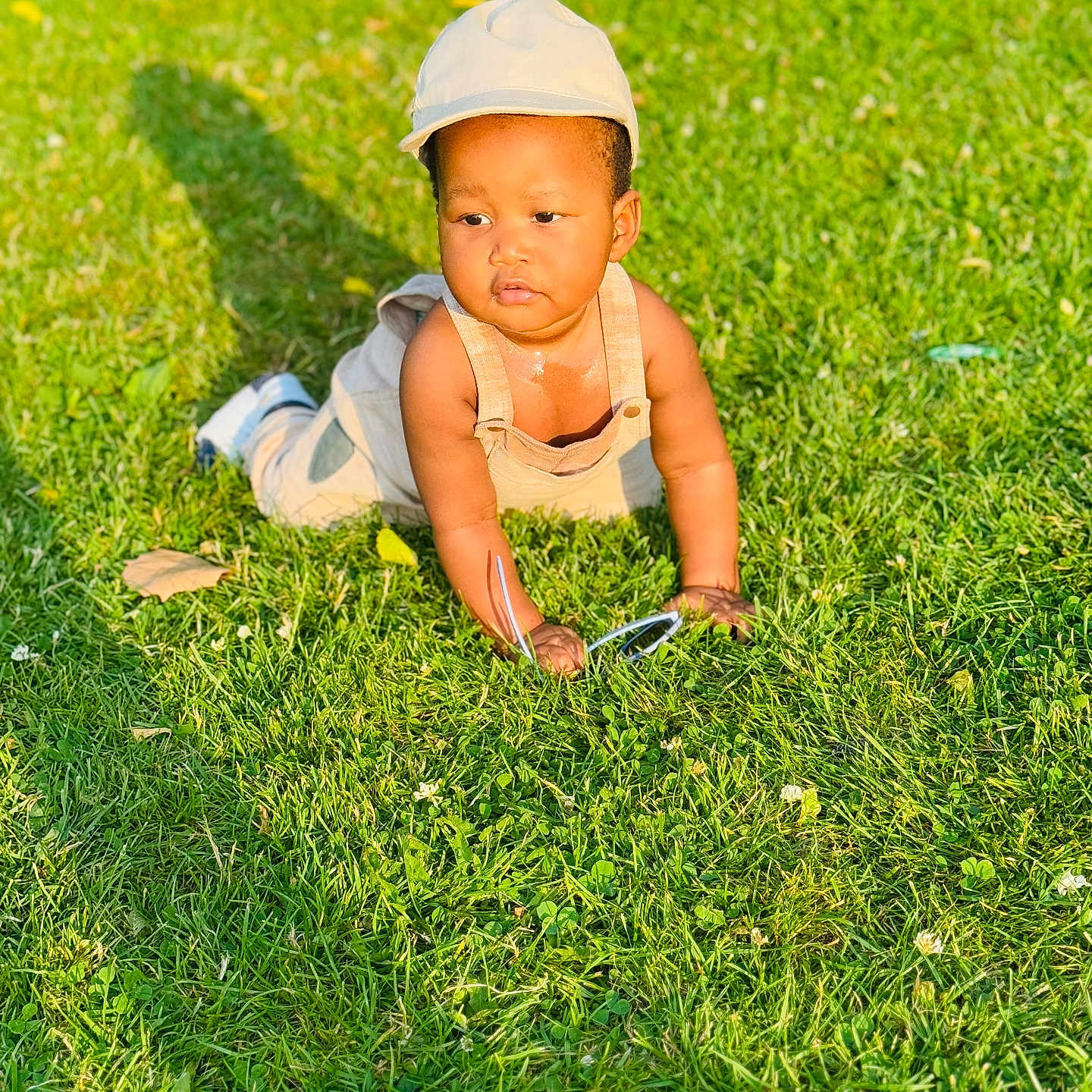 Ryo joined the competition — help win amazing prizes! baby, cap, casual_clothing, child, crawling, cute, daytime, grass, greenery, infant, nature, outdoor, overalls, person, playful, portrait, shadow, summer, sunglasses, sunlight